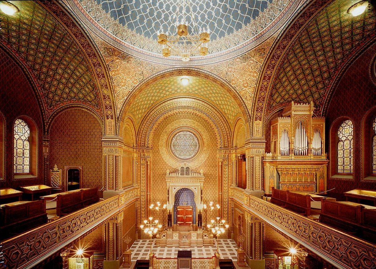 Interiér Španělské synagogy v Praze, s barevnými vitrážemi a bohatě zdobeným interiérem.