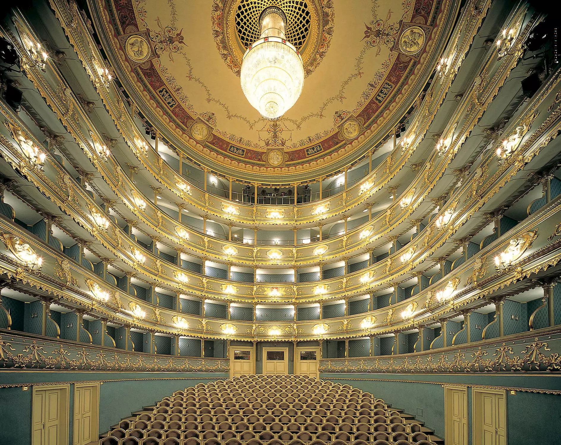 nterior of the Estates Theatre in Prague with rich decorations and chandeliers